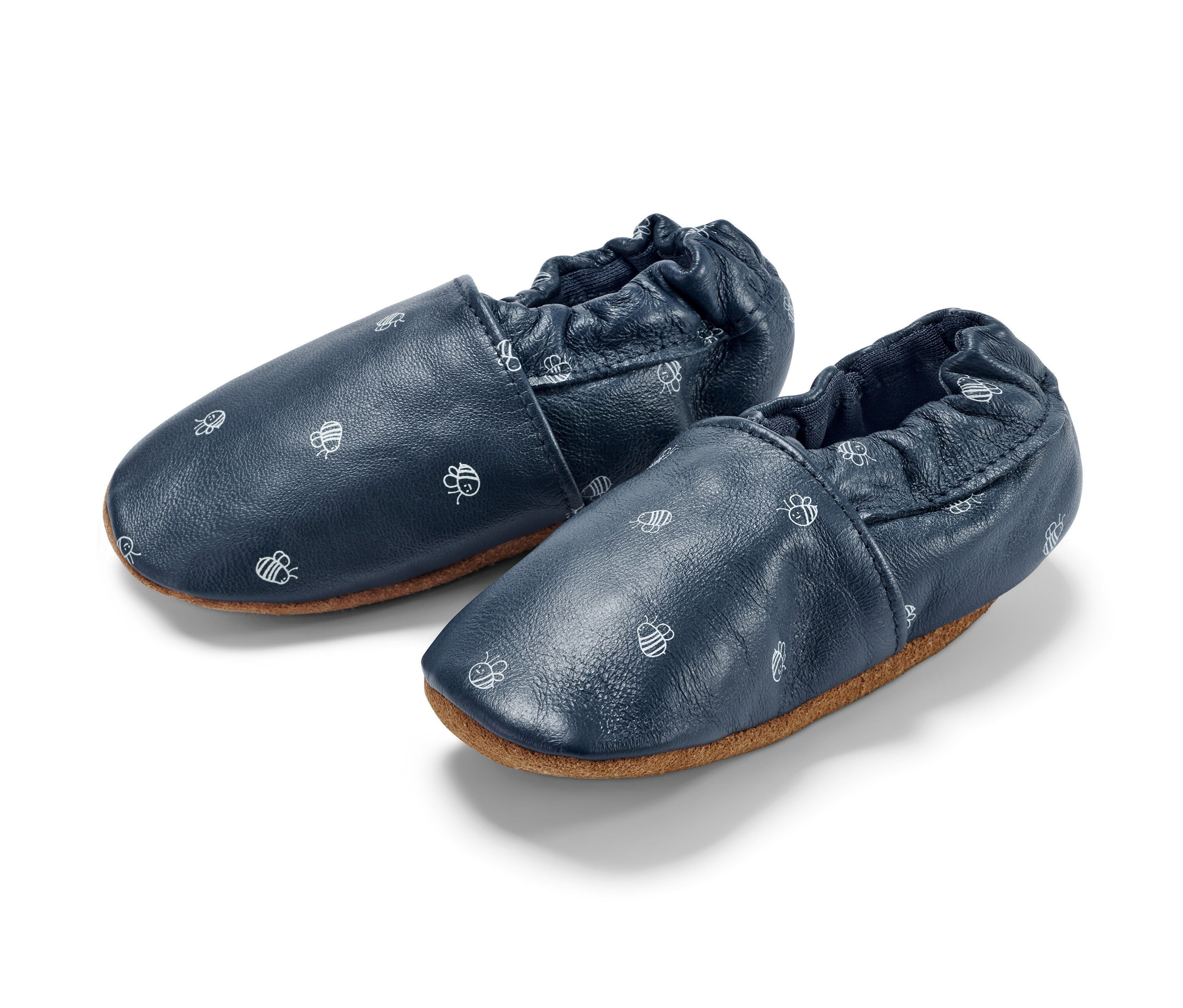 Deux petites chaussures en cuir pour bébé avec un motif d'abeilles.