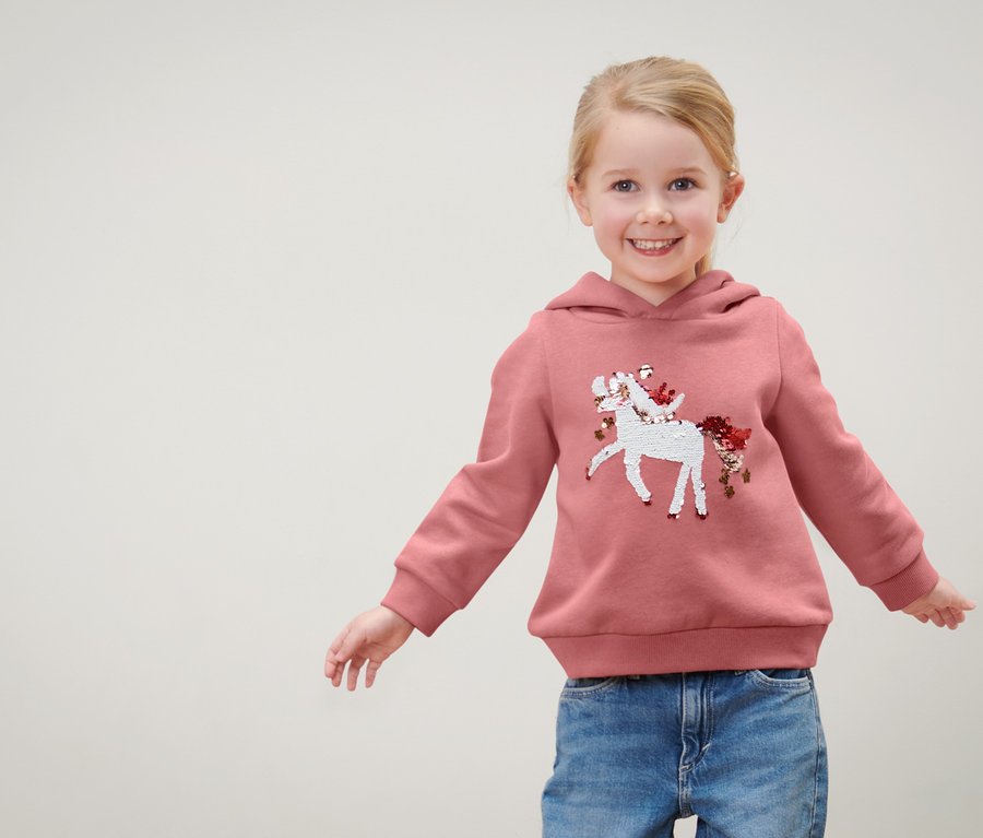 Fillette portant un sweat-shirt pour enfant avec motif en paillettes réversibles, licorne.
