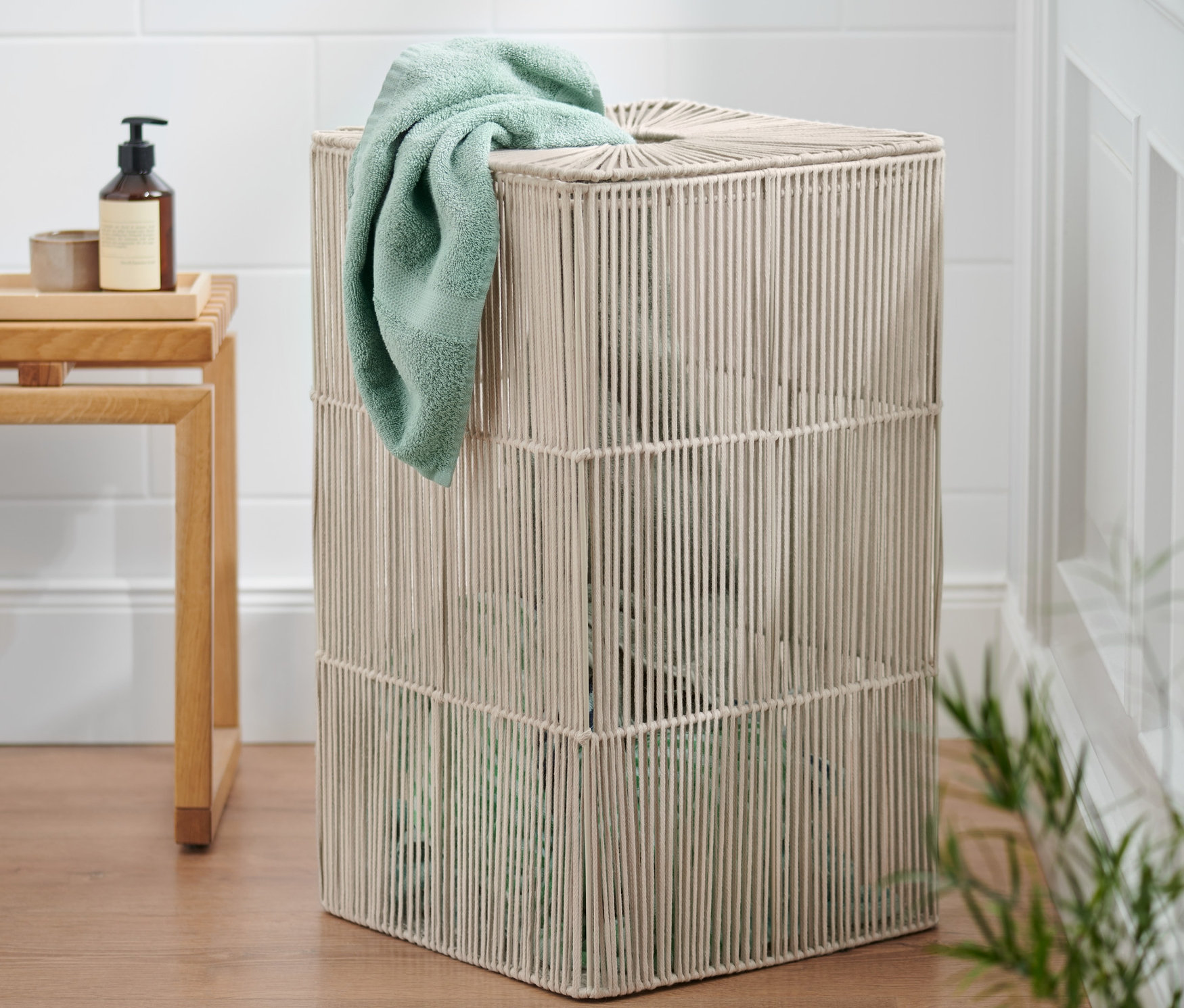 Un bac à linge avec une serviette verdâtre drapée sur le bord.