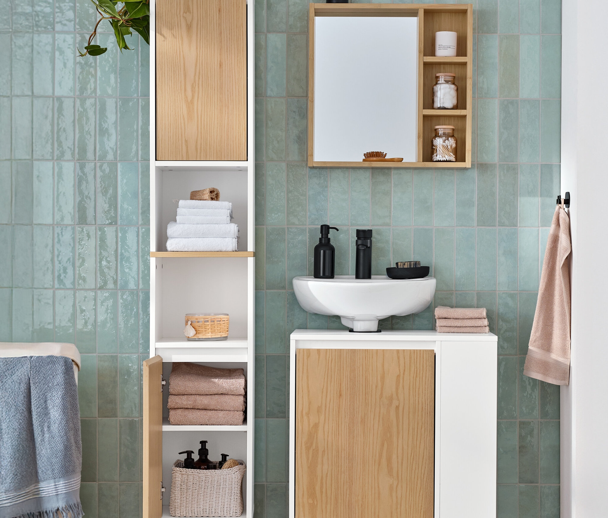 Une salle de bain comprend une armoire haute de salle de bain avec un compartiment ouvert et 2 portes, un meuble sous-vasque avec une porte et un compartiment latéral, et un miroir avec des étagères.