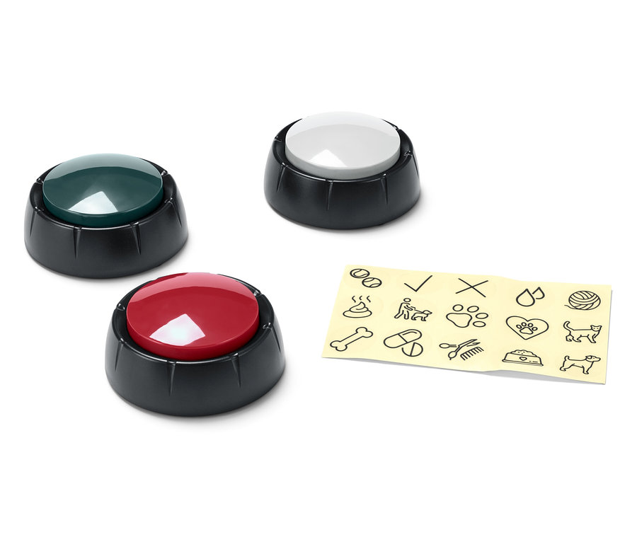 Trois boutons de différentes couleurs (vert, blanc et rouge) à côté d'un morceau de papier jaune avec des dessins noirs.