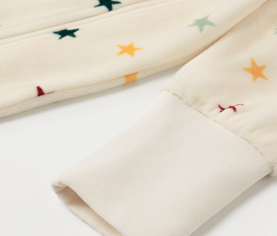 Gros plan sur un pyjama en nicki pour bébé avec des étoiles.