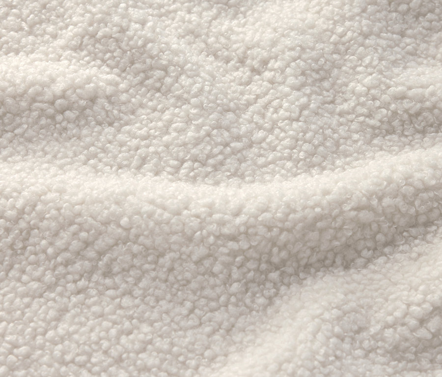 Gros plan d'un tissu blanc crème avec une texture sherpa.