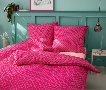 Parure de lit en microfibre rose de taille standard et grande taille sur un lit.