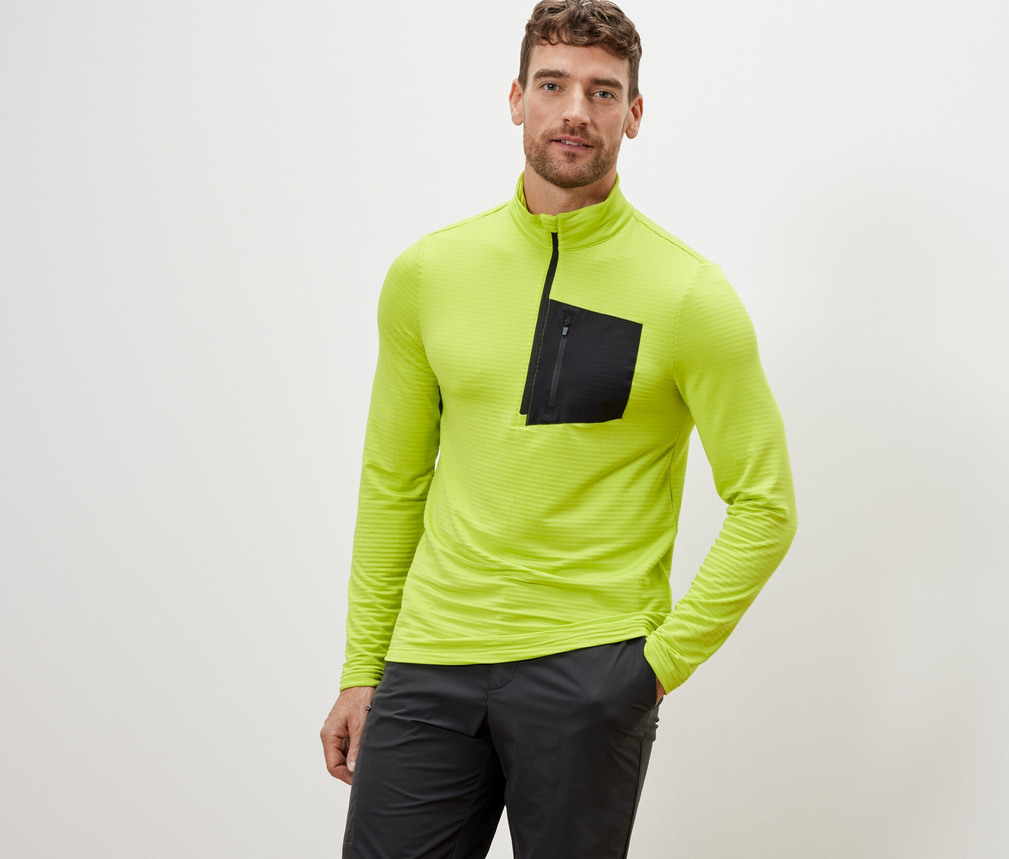 Un homme pose avec une chemise fonctionnelle outdoor citron vert.