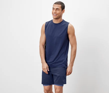 Un homme portant un débardeur et un short.