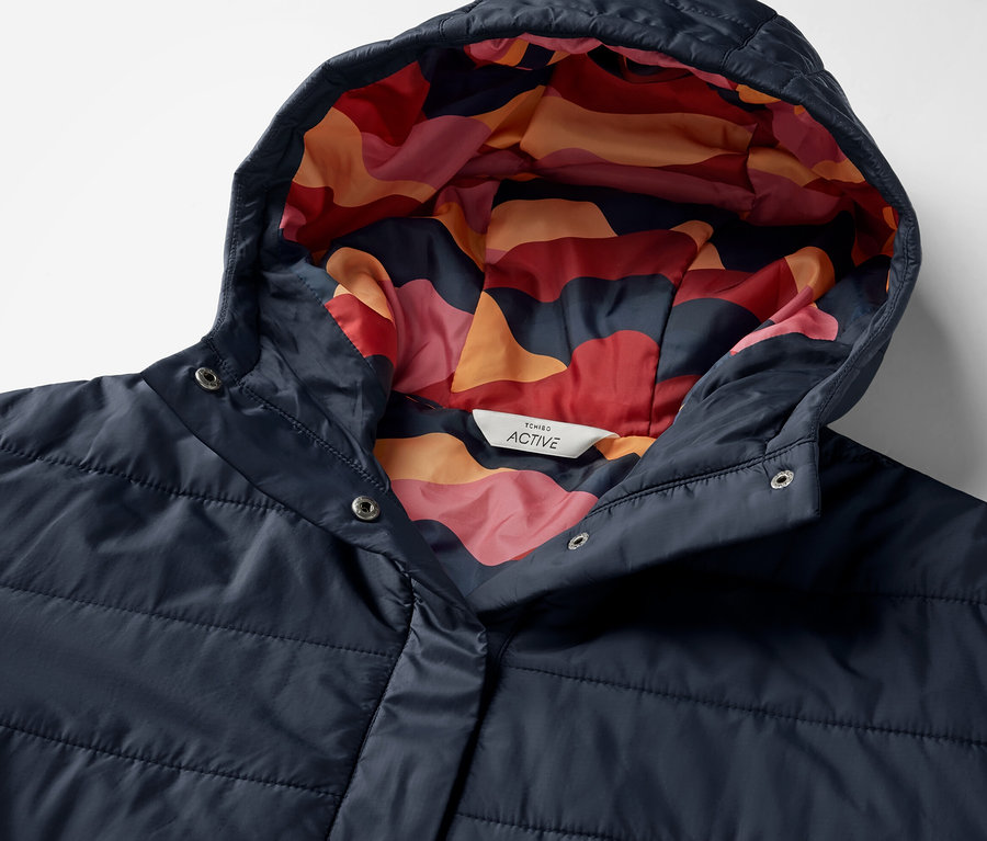 Vue détaillée d'un poncho d'extérieur bleu avec capuche et motif coloré à l'intérieur.