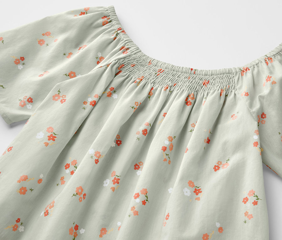 Blouse pour enfant vert clair avec motif floral.
