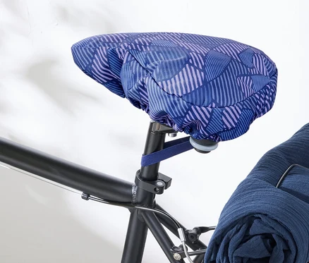 Gros plan d'un vélo avec une housse de selle de vélo bleu et violet.