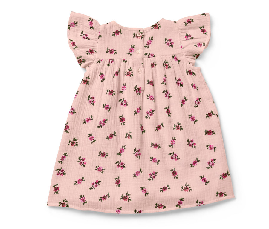 Une robe en mousseline pour bébé avec un motif floral.