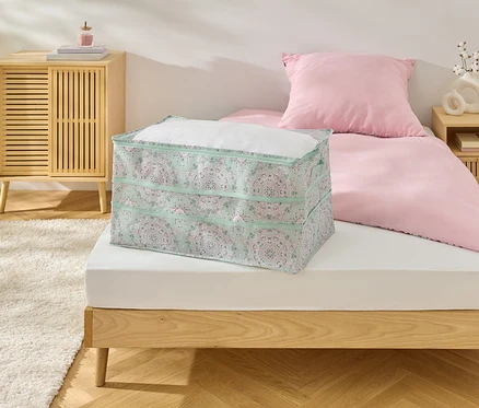 Un espace de rangement Jumbo est posé sur un lit.