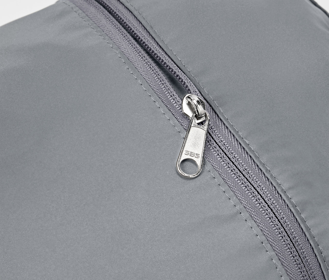 Gros plan d'un sac à dos réfléchissant gris avec une fermeture éclair argentée.
