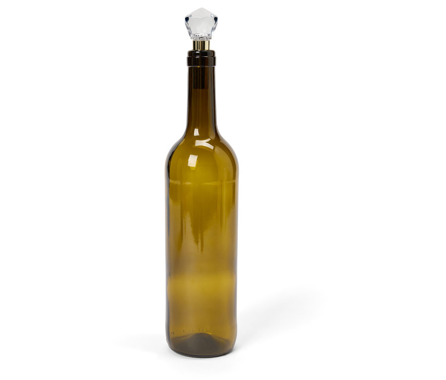 Une bouteille en verre verte avec un bouchon en cristal sur fond blanc.