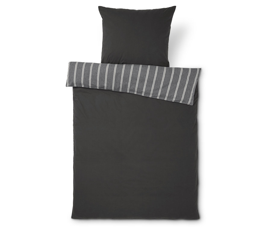 Linge de lit gris foncé avec bordure rayée et oreiller.