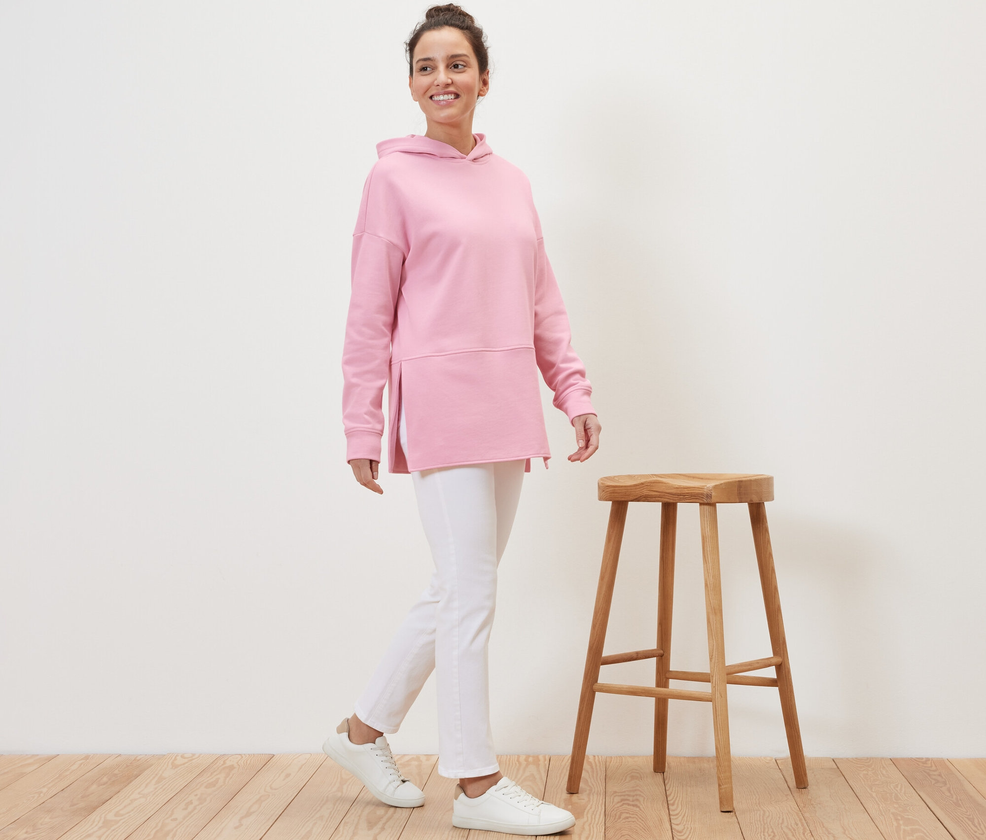 Femme marchant et portant un sweat-shirt long à capuche rose.