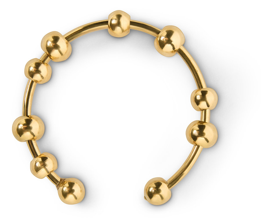 Bracelet de bras ouvert doré avec des billes sur fond blanc.