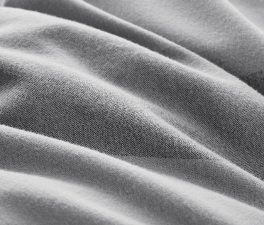 Gros plan d'un tissu gris texturé avec des plis.