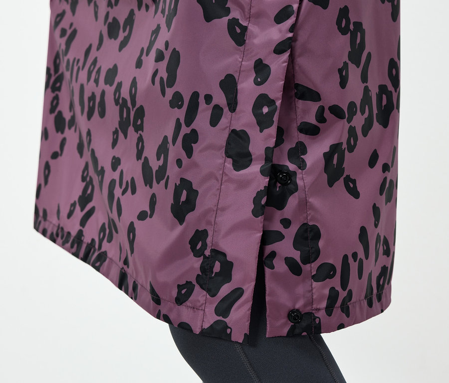 Détail d'une veste violette avec un motif animal noir et des boutons sur le côté.