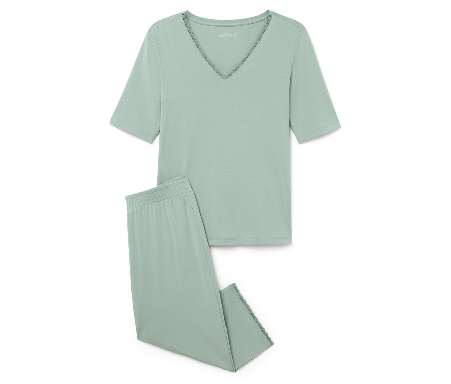 Un pyjama vert clair composé d'un haut à manches courtes et d'un pantalon posé sur un fond blanc.