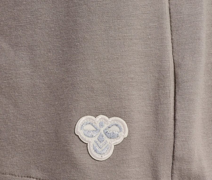Gros plan d'un tissu gris avec un petit logo blanc cousu.