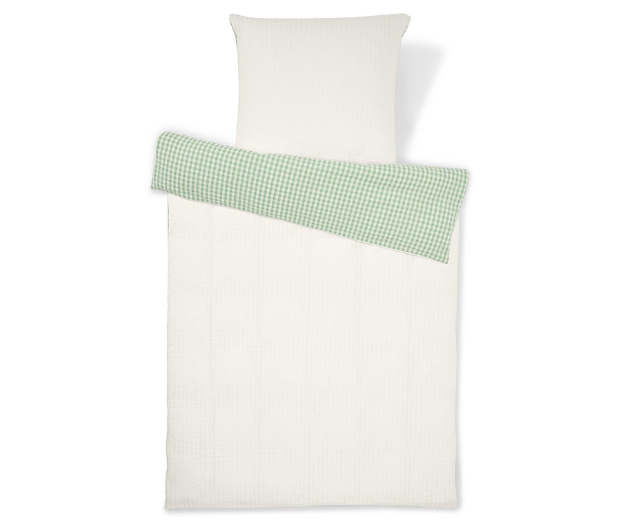 Ensemble de literie comprenant une taie d'oreiller blanche et une housse de couette blanche avec un détail à carreaux verts.