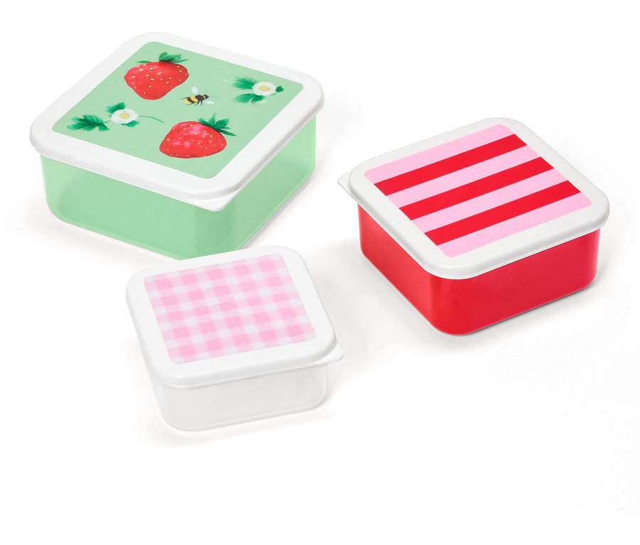 Trois boîtes à lunch carrées avec différents motifs sur les couvercles : fraises, rayures et carreaux.