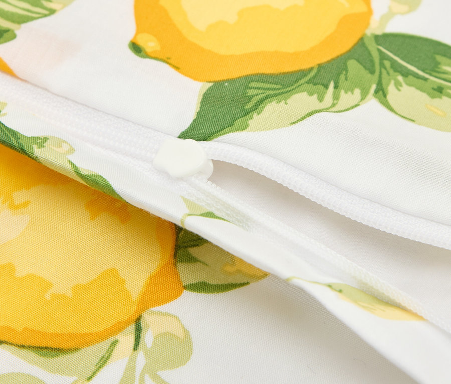 Gros plan d'un tissu blanc à motif citron avec une fermeture éclair blanche.