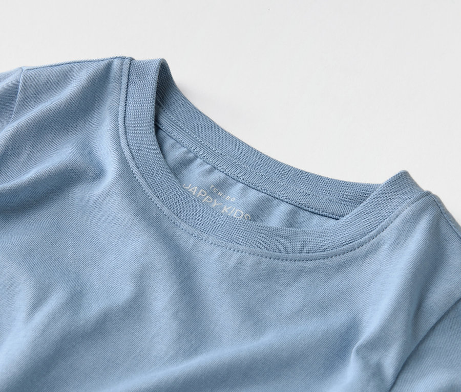 Gros plan d'un t-shirt bleu clair avec l'inscription "JAPPY KIDS" sur le col.