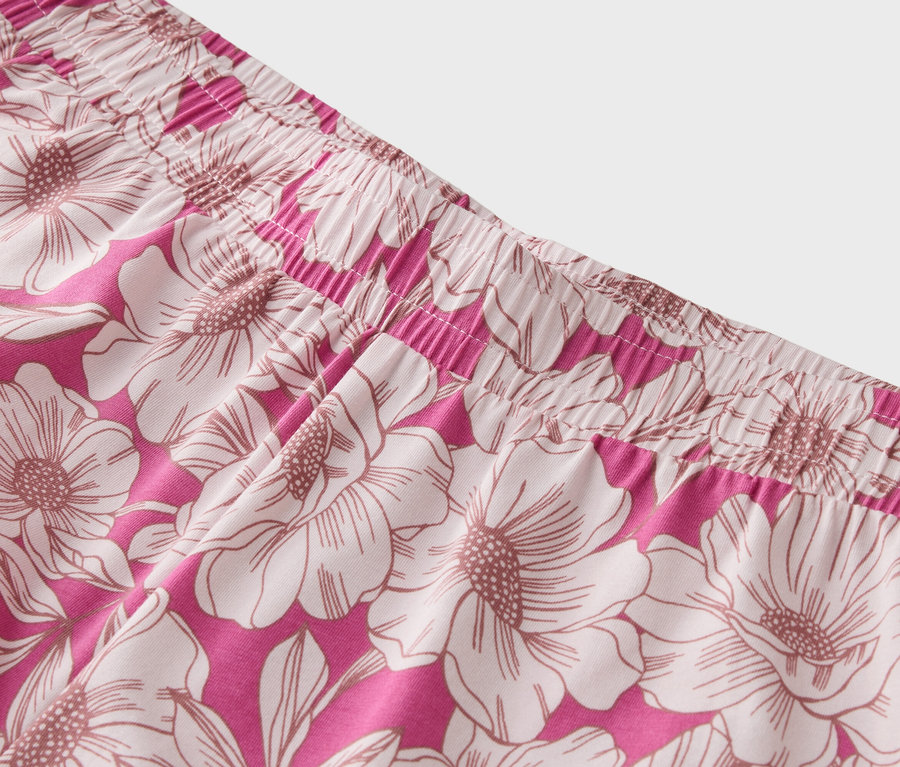 Gros plan de la ceinture d'un pantalon rose à motifs floraux.