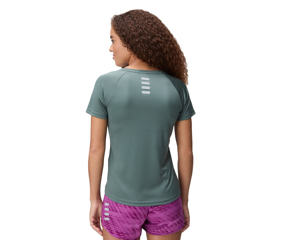 Vue arrière d'une femme aux cheveux bouclés portant un haut de sport vert et un short violet.