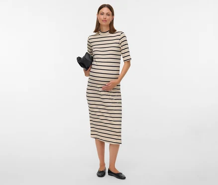 Femme enceinte en robe rayée tenant un sac noir.