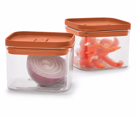 Deux récipients carrés transparents avec des couvercles orange. L'un contient un oignon rouge, l'autre des poivrons rouges coupés.