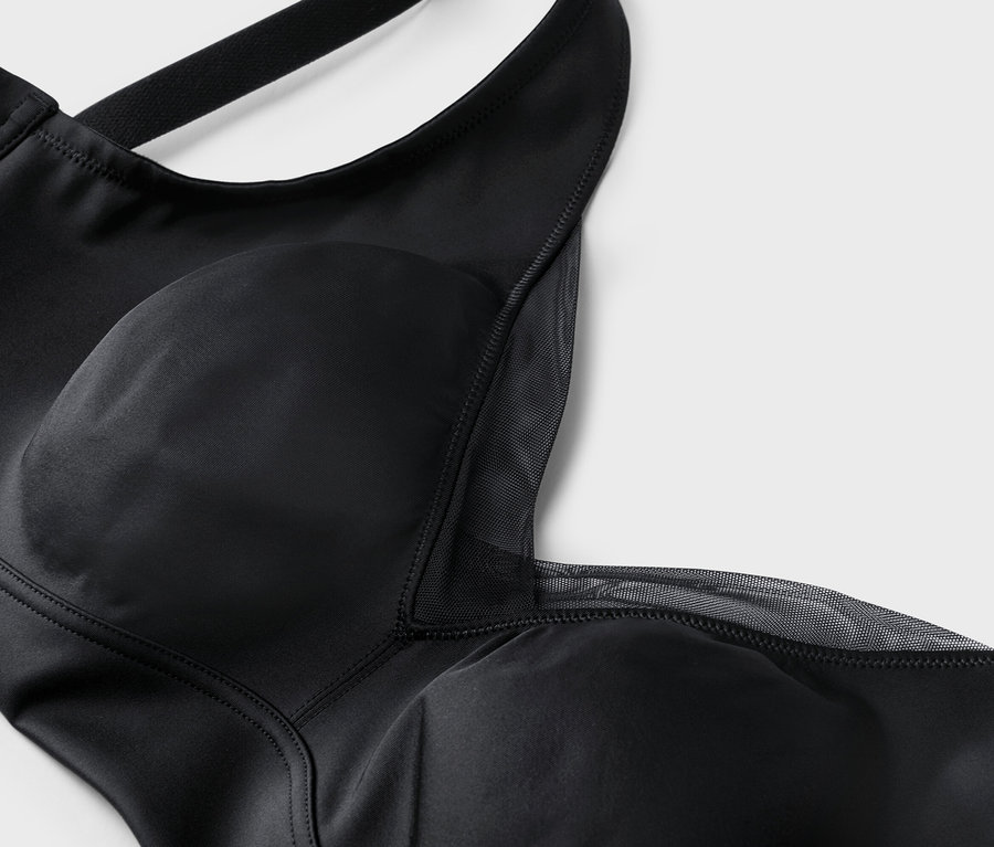 Gros plan d'un soutien-gorge noir avec de larges bretelles et des détails en maille.