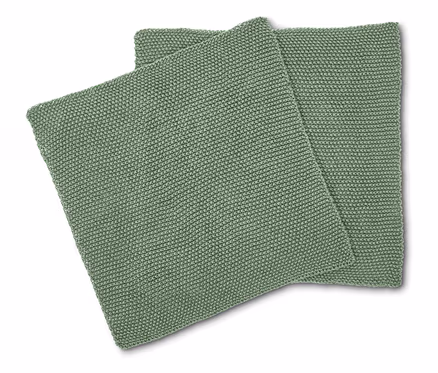Deux coussins carrés vert clair avec un motif tricoté sont superposés.
