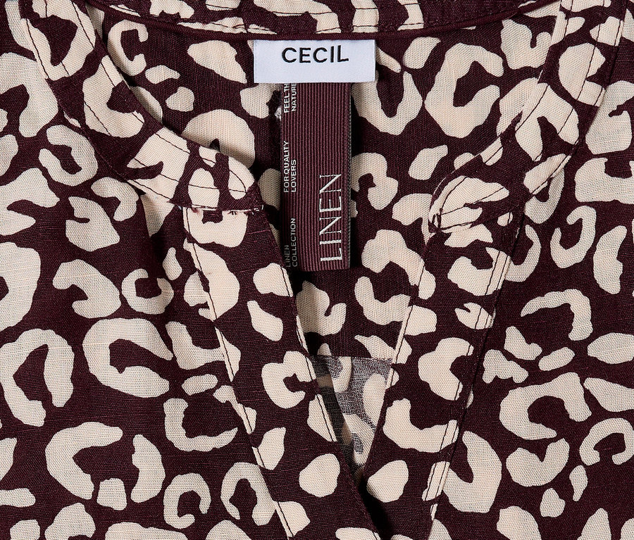 Gros plan sur un haut CECIL à motif léopard marron et beige avec une étiquette LINEN.