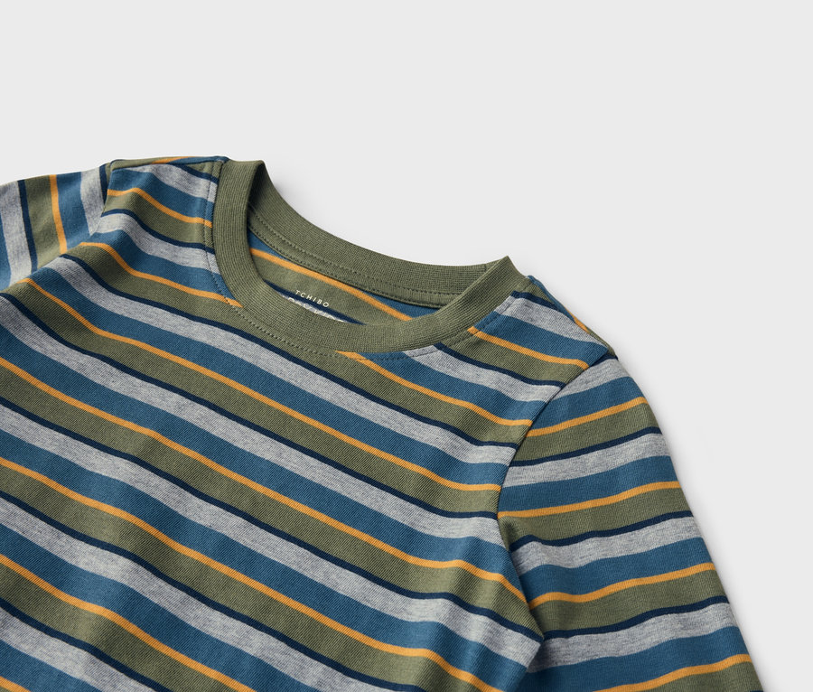 Gros plan d'un t-shirt à manches longues à rayures horizontales bleues, grises, vertes et jaunes sur fond blanc.