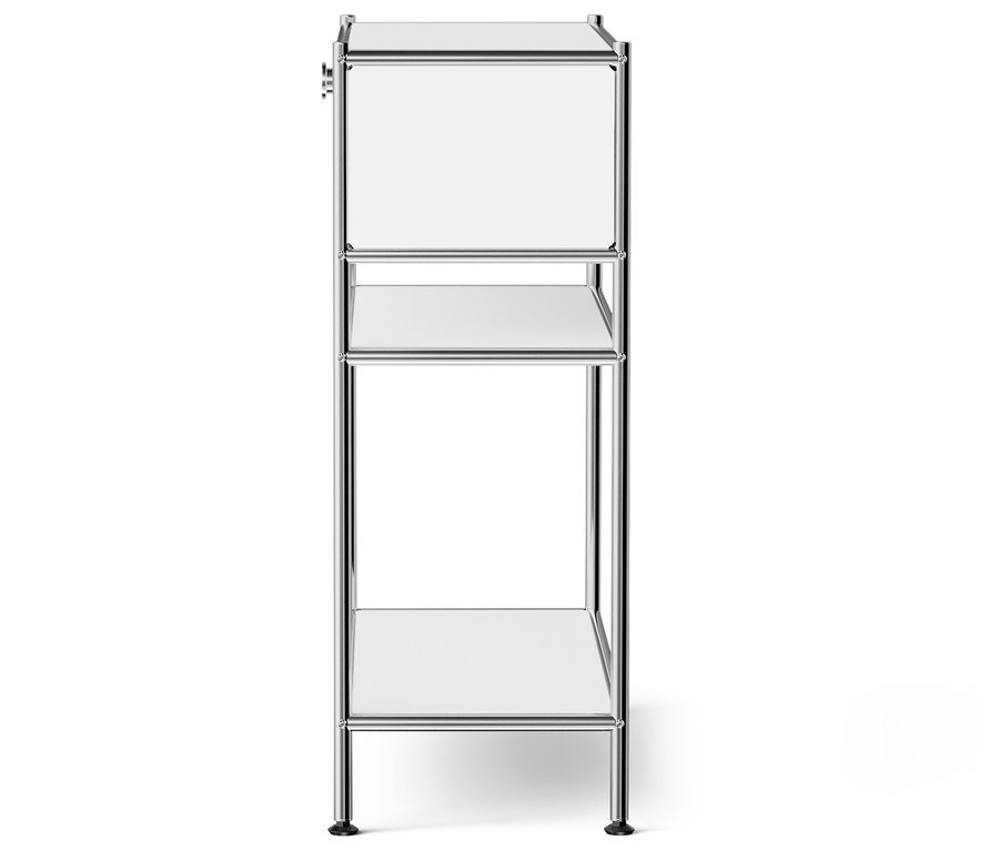 Une structure d'étagère étroite argentée avec des étagères blanches se dresse sur un fond blanc.