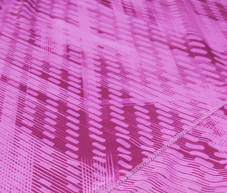 Gros plan d'un tissu rose avec un motif géométrique et le logo FILA.