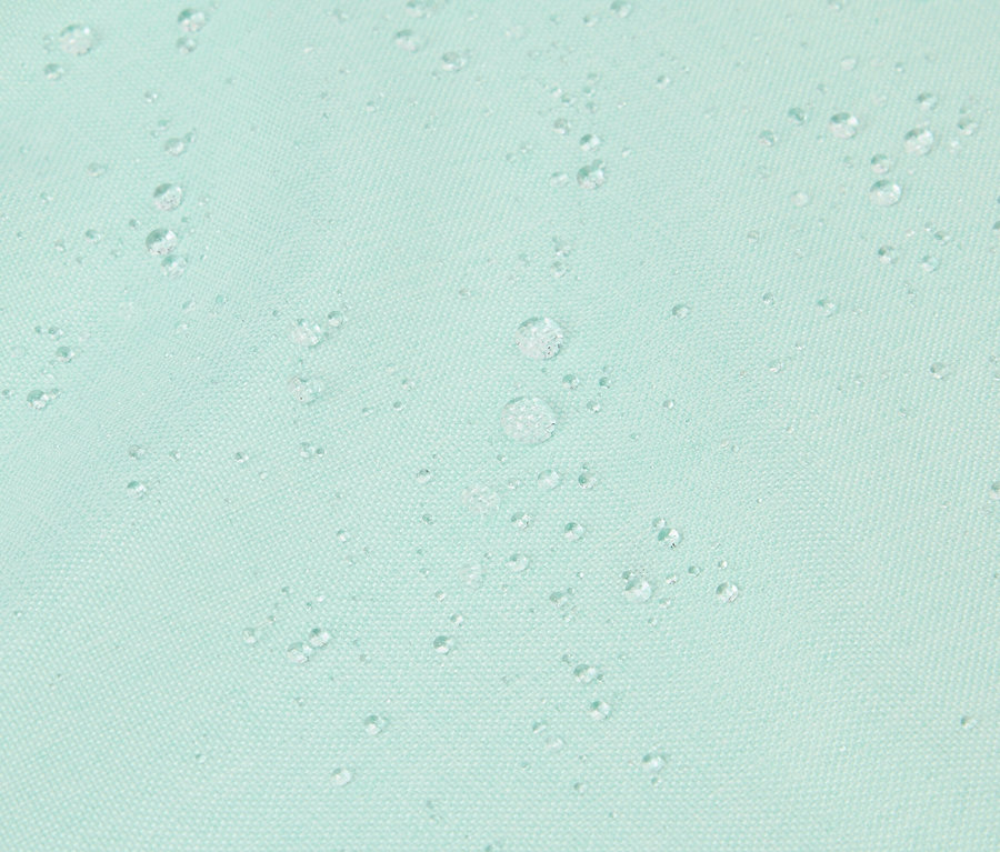 Gros plan de gouttes d'eau sur un tissu turquoise.