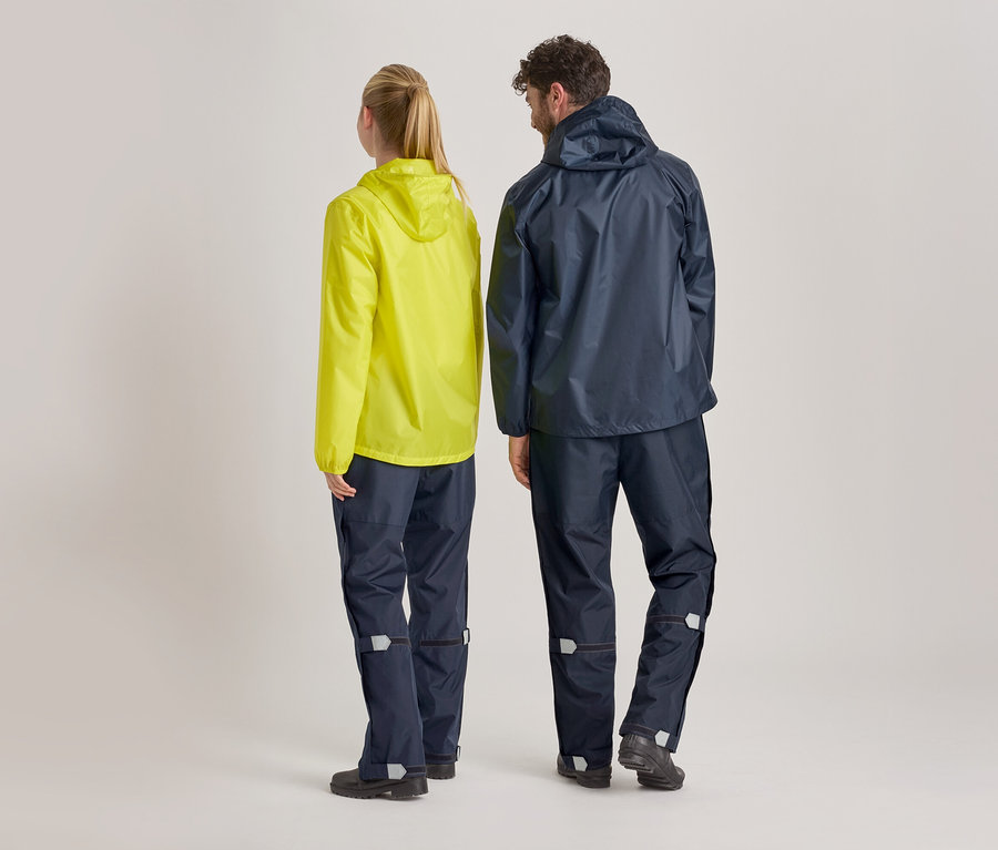 Vue arrière d'une femme portant un imperméable jaune et d'un homme portant un imperméable et un pantalon de pluie bleu marine sur un fond clair.