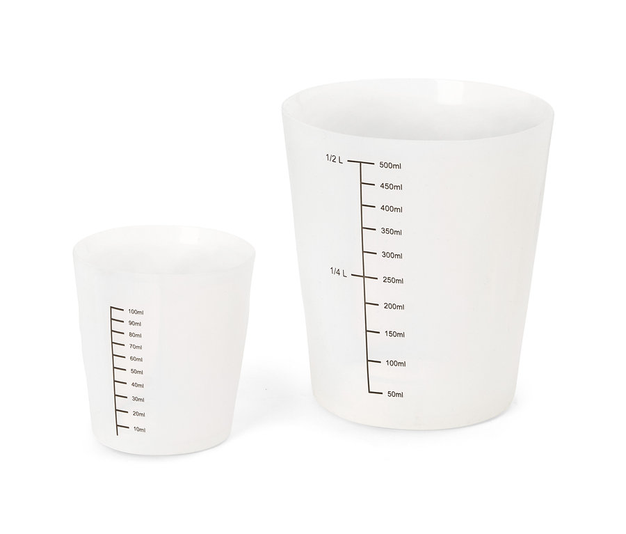 Deux tasses à mesurer blanches translucides, une plus petite (10-100ml) et une plus grande (50-500ml, 1/4 L, 1/2 L).