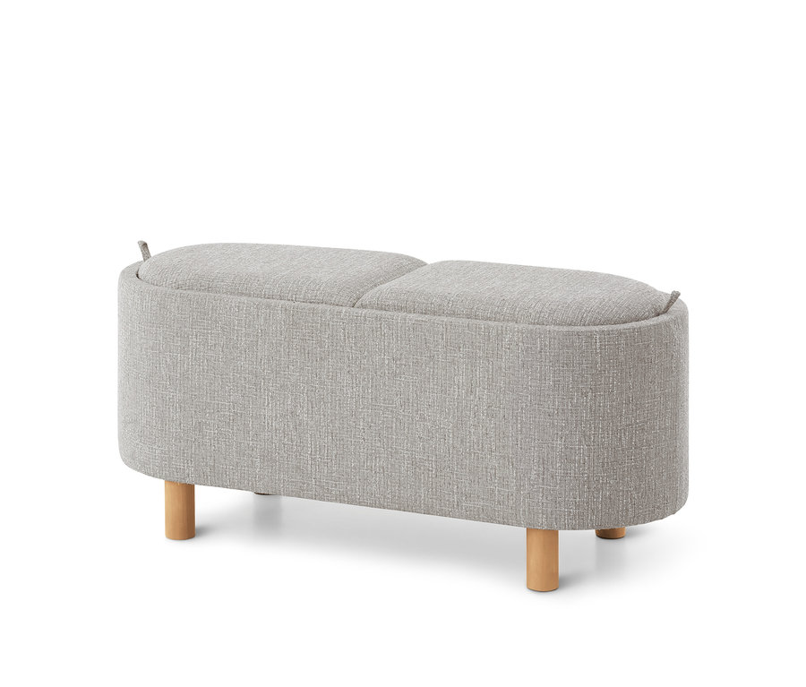 Un banc rembourré gris clair avec un dessus divisé et de courts pieds en bois.