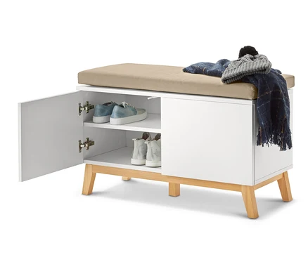 Banc blanc ouvert avec des étagères de rangement, sur lequel reposent des chaussures, une couverture et un chapeau.