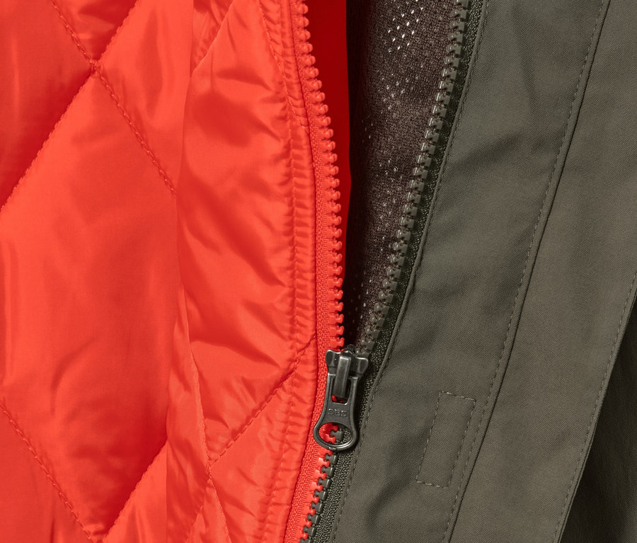 Gros plan sur un manteau de pluie olive 3-en-1 avec un gilet orange et une fermeture éclair.