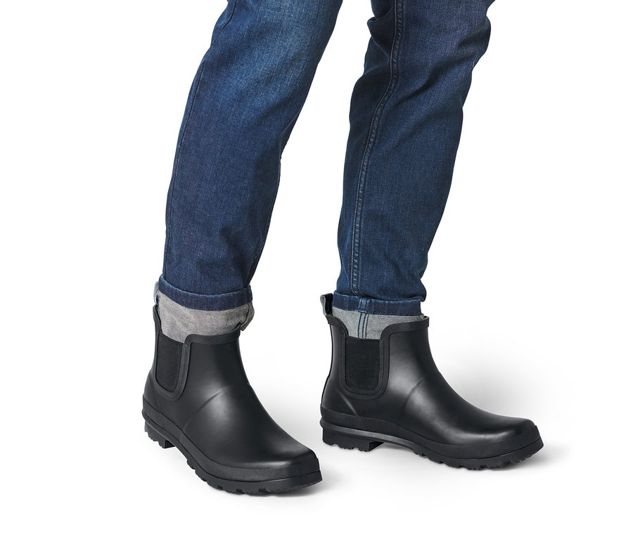 Jambes en jean et bottines Chelsea de pluie noires.