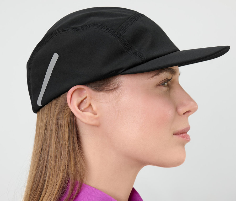 Profil d'une femme portant une casquette de course noire.