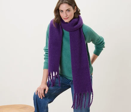 Femme posant avec une écharpe tissée violette.