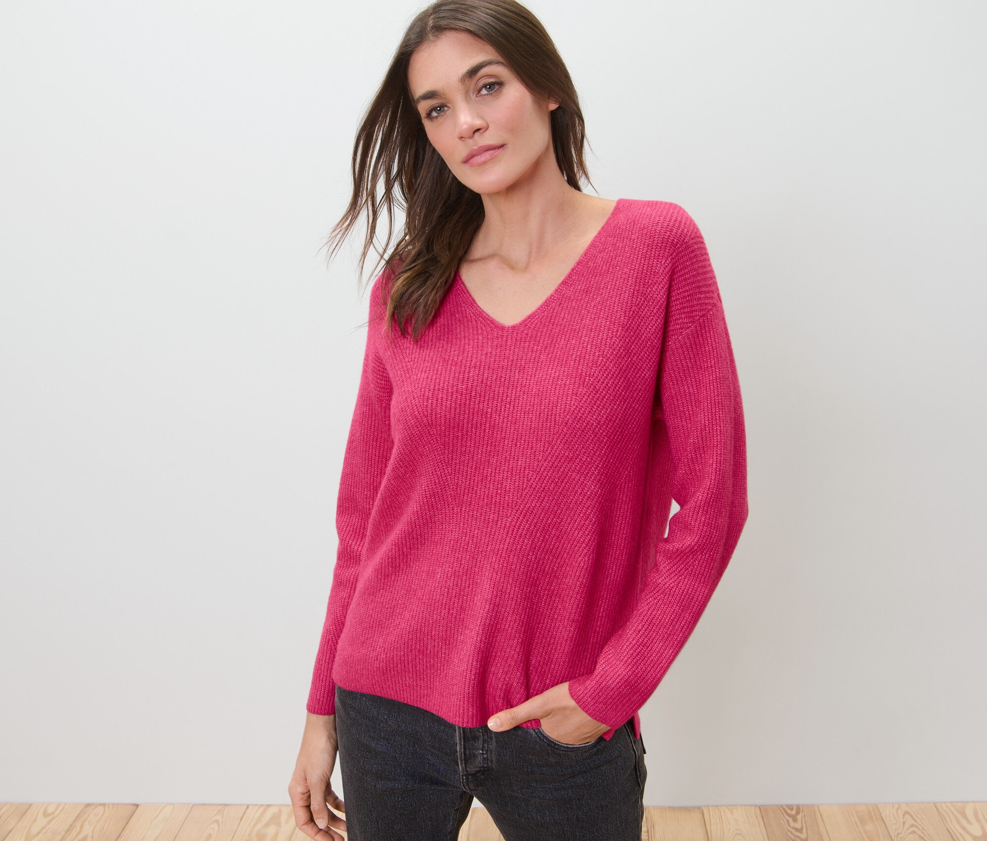 Femme posant en pull en grosse maille framboise.