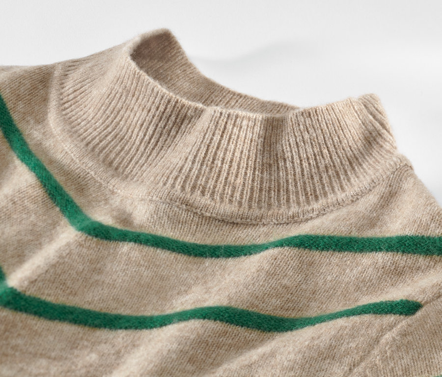 Gros plan sur un pull rayé en maille à col montant, crème.