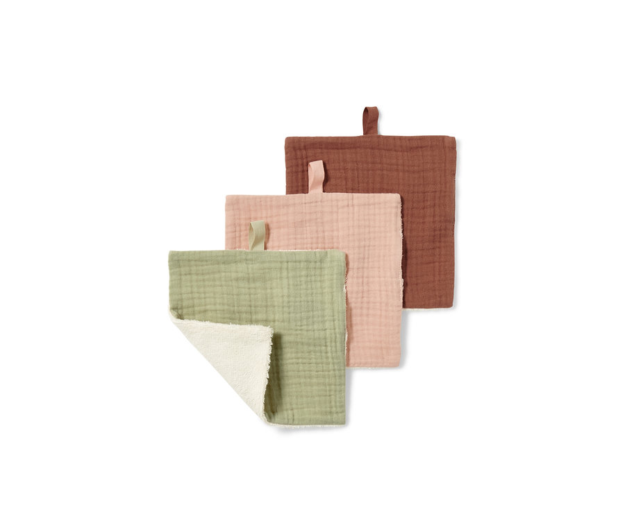 Trois lingettes démaquillantes, verte, rose et rouille. La lingette verte est partiellement repliée, de sorte que le côté blanc est visible.